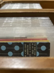 1950s American matchbooks stored in protective sleeves inside a wooden case.